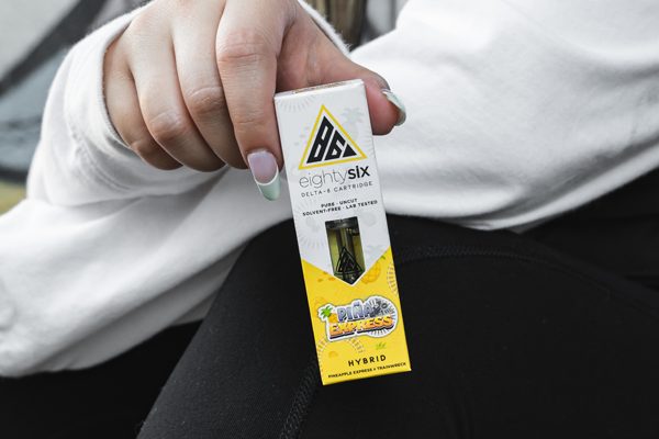 A girl holding delta-8 cartridge